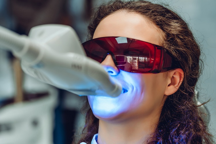 歯科でサングラスで目を守りながらオフィスクリーニングを受ける女性