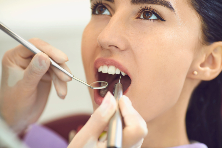 歯鏡で歯を検査する女性