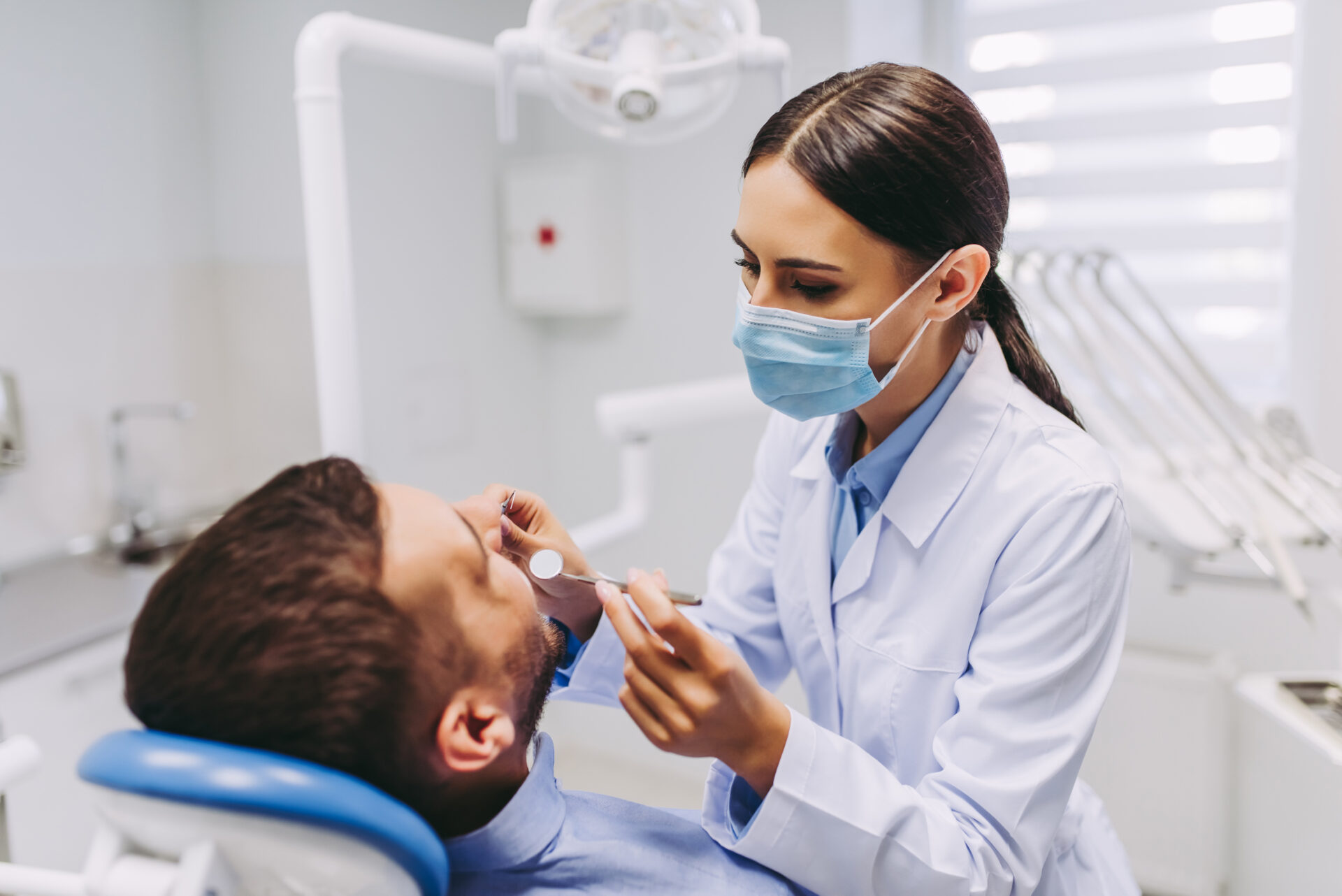 歯科医院で患者の口内を確認する女性歯科医師