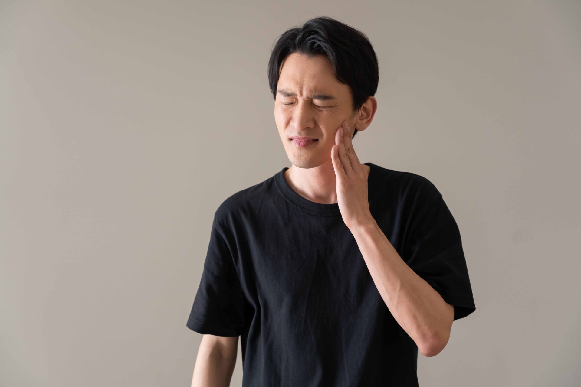頬に手を当てている男性